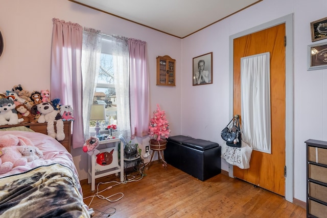 bedroom with ornamental molding and hardwood / wood-style flooring