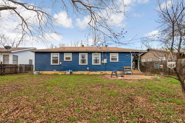 back of house featuring a lawn and a patio