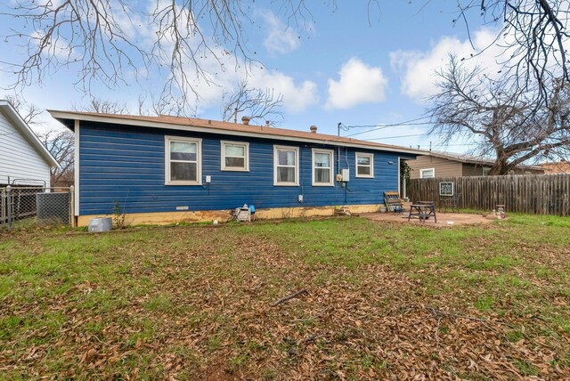 back of property with a patio area and a yard