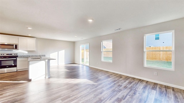 kitchen with light hardwood / wood-style floors, sink, white cabinetry, and appliances with stainless steel finishes