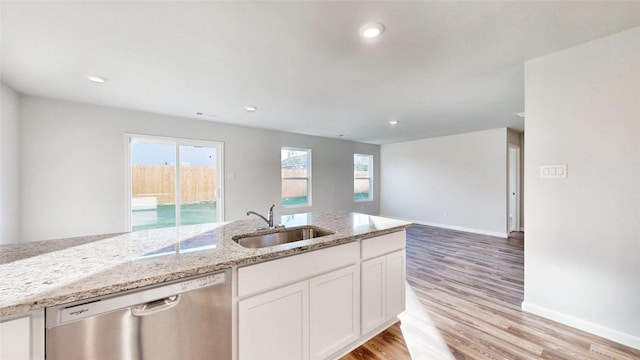 kitchen featuring dishwasher, white cabinetry, light hardwood / wood-style floors, sink, and light stone counters