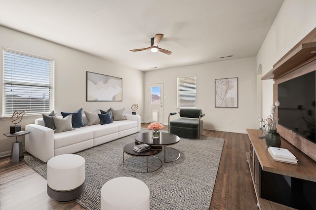 living room featuring ceiling fan and dark hardwood / wood-style floors