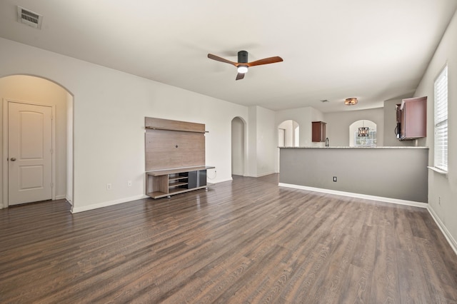 unfurnished living room featuring ceiling fan and dark hardwood / wood-style flooring