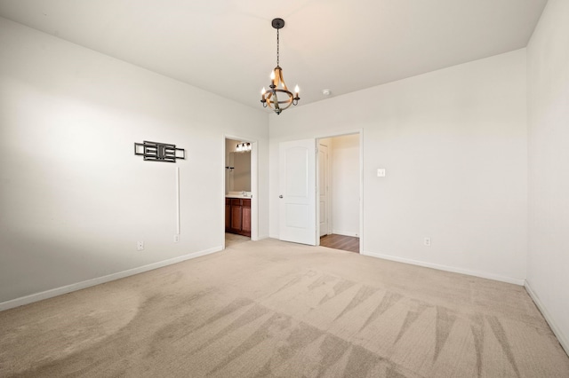 carpeted empty room featuring a chandelier