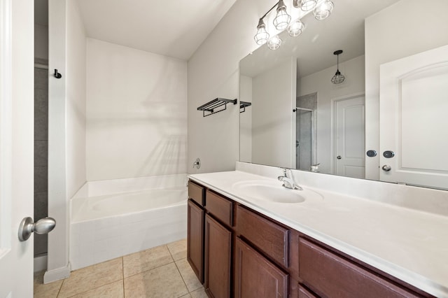 bathroom featuring tiled tub, vanity, and tile patterned flooring