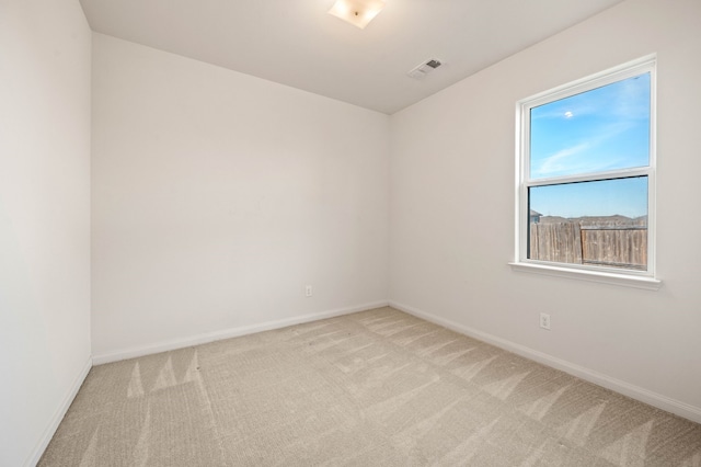 spare room featuring light colored carpet