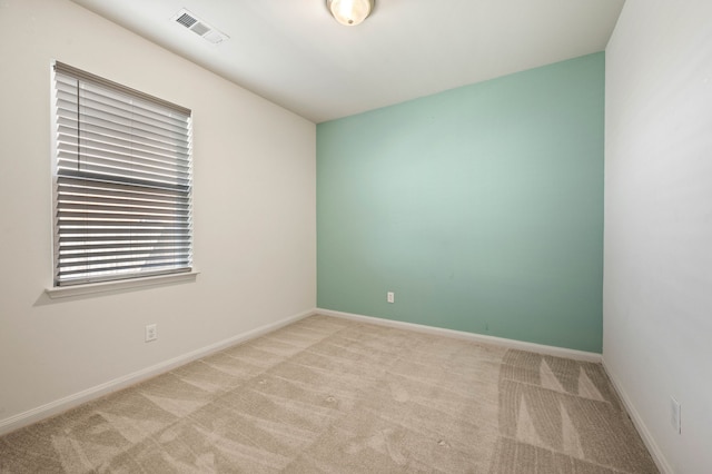 spare room featuring light colored carpet