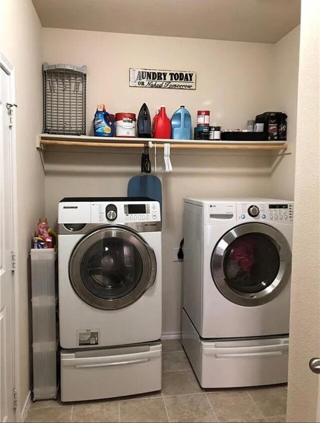 laundry area featuring laundry area, light tile patterned flooring, and separate washer and dryer