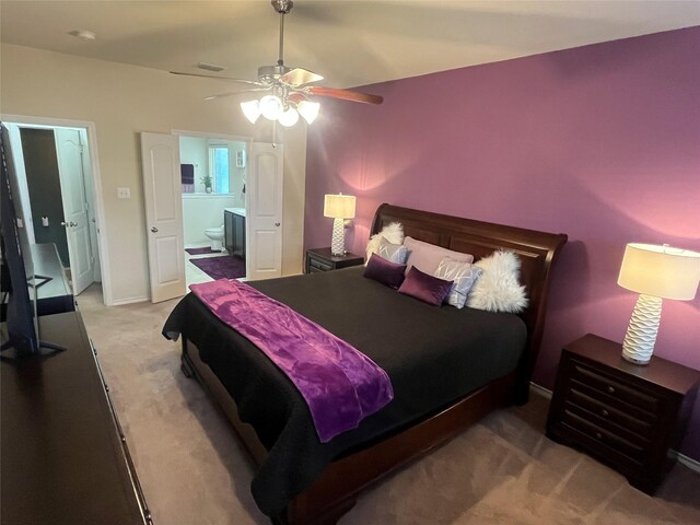 bedroom featuring ceiling fan, connected bathroom, light carpet, visible vents, and baseboards