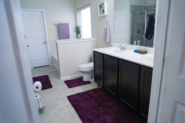 bathroom featuring a washtub, double vanity, a sink, a shower stall, and tile patterned flooring