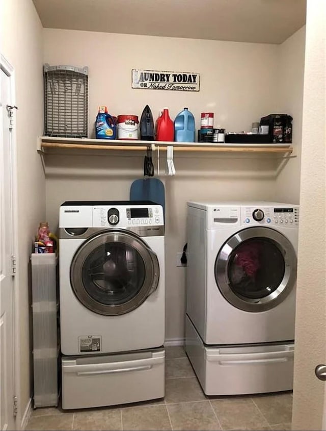 clothes washing area featuring washer and dryer and light tile patterned flooring