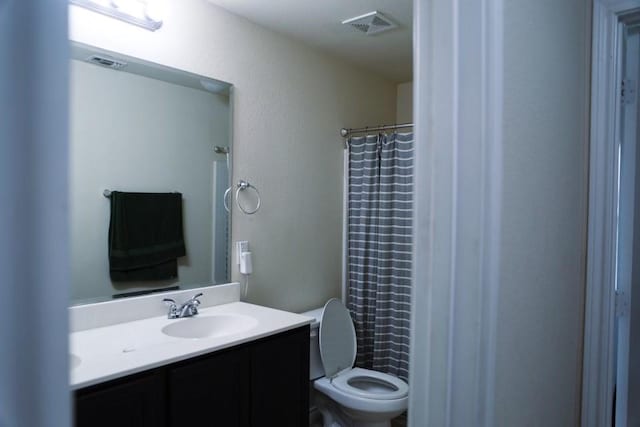 bathroom with toilet, a shower with curtain, visible vents, and vanity