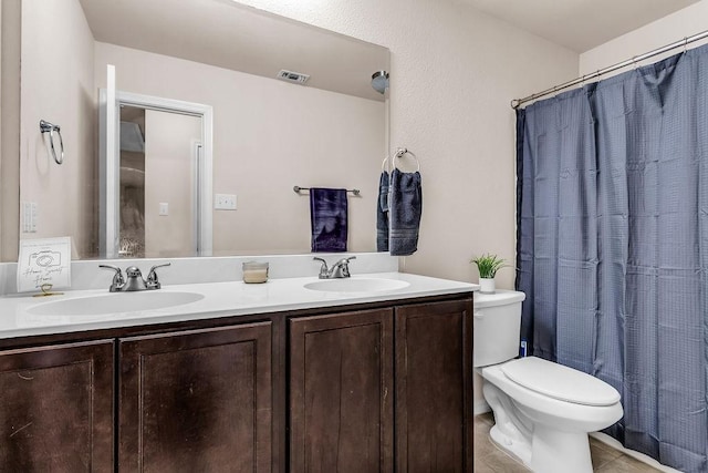 full bathroom featuring toilet, double vanity, a shower with curtain, and tile patterned floors