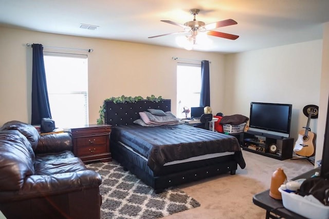 carpeted bedroom featuring a ceiling fan and visible vents