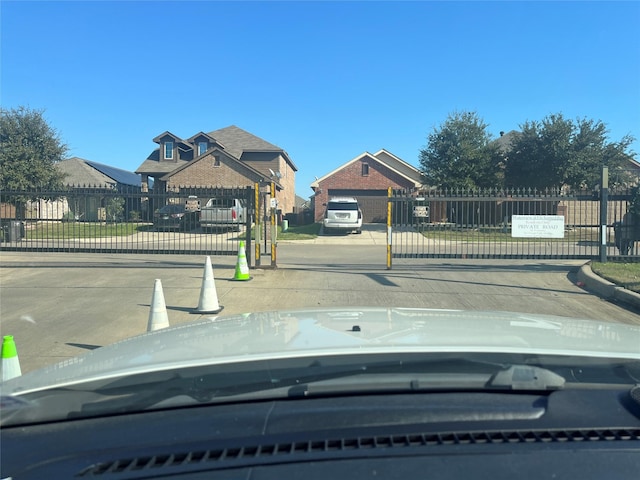 view of road with curbs, a gated entry, and a gate