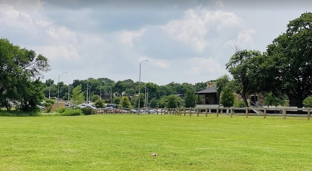 view of property's community with a lawn and fence