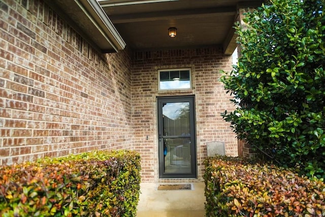 doorway to property with brick siding