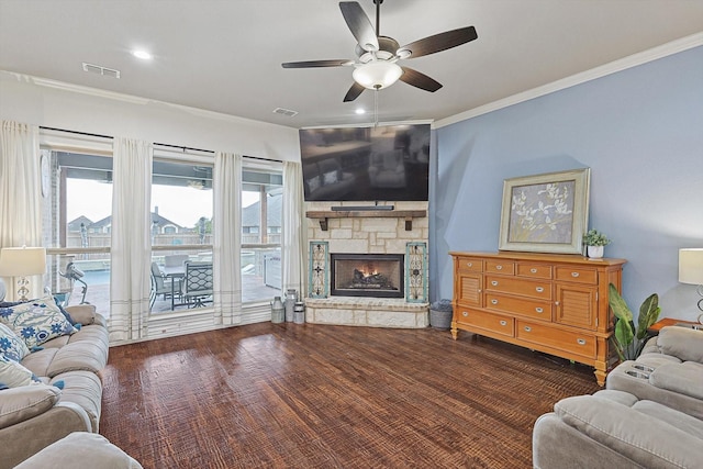 living room with ceiling fan, ornamental molding, a fireplace, and dark hardwood / wood-style floors