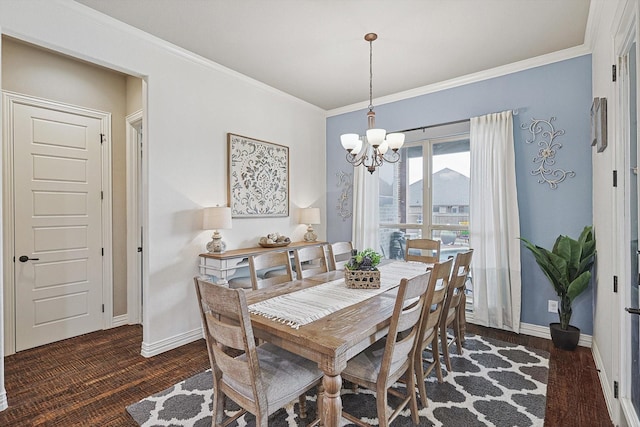 dining room with dark hardwood / wood-style flooring, crown molding, and an inviting chandelier