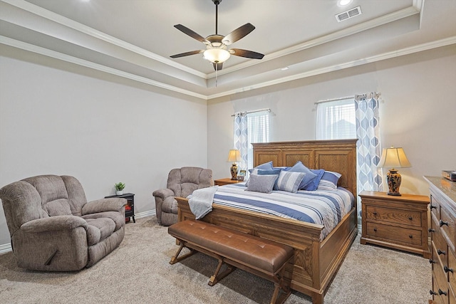 carpeted bedroom featuring ceiling fan, a tray ceiling, and ornamental molding