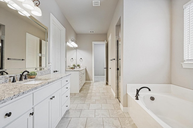 bathroom with vanity, tile patterned floors, and a relaxing tiled tub