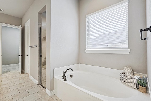 bathroom featuring independent shower and bath, a wealth of natural light, and tile patterned flooring