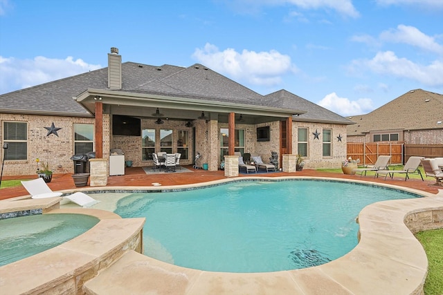 view of swimming pool with ceiling fan, an in ground hot tub, and a patio