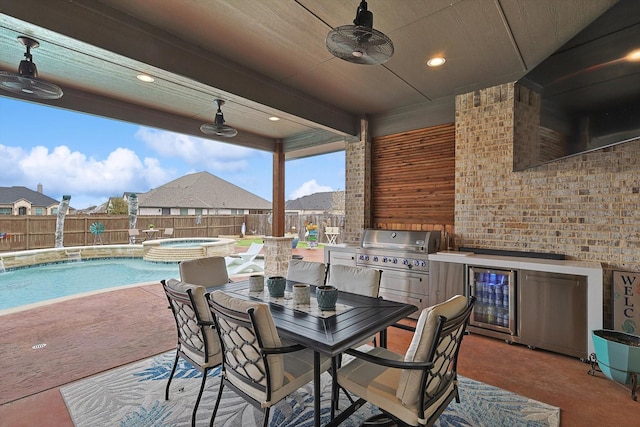 view of patio / terrace featuring wine cooler, an outdoor kitchen, a pool with hot tub, and ceiling fan