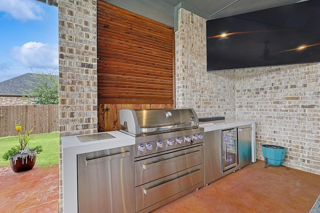 view of patio / terrace featuring beverage cooler, an outdoor kitchen, and grilling area