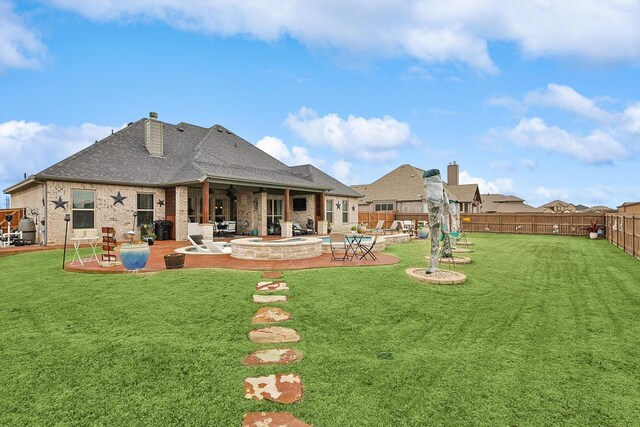 rear view of house with a lawn and a patio