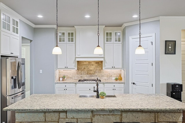 kitchen featuring white cabinetry, appliances with stainless steel finishes, backsplash, a kitchen island with sink, and pendant lighting