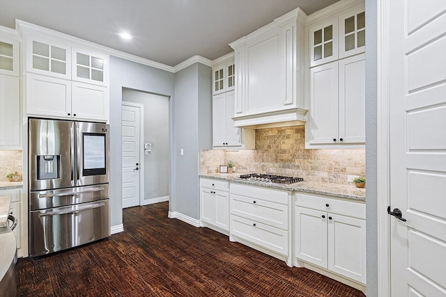 kitchen with light stone countertops, white cabinets, appliances with stainless steel finishes, dark wood-type flooring, and ornamental molding