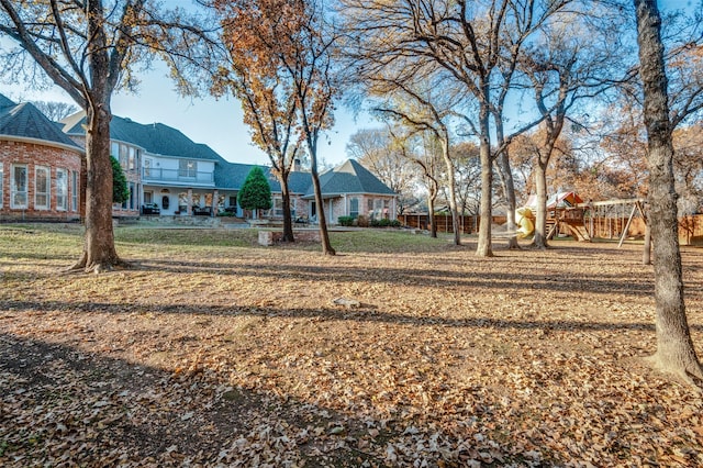 view of yard with a playground and a balcony