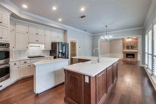 kitchen with sink, a center island with sink, white cabinetry, and stainless steel appliances