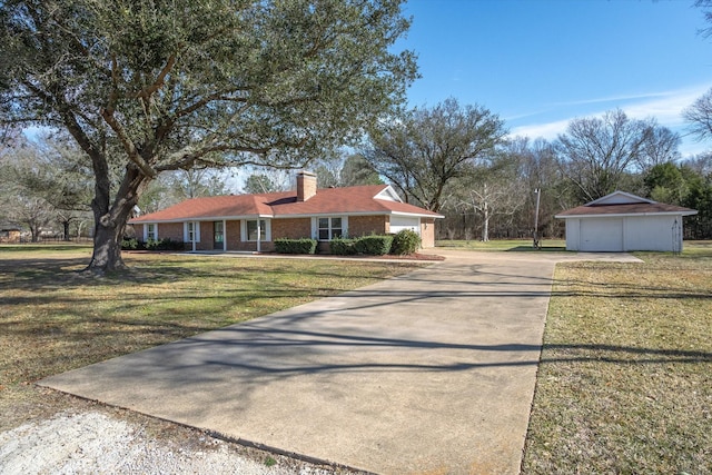 view of front of home featuring a front yard, a garage, and an outdoor structure