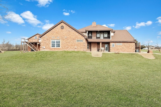 back of house featuring a balcony and a lawn