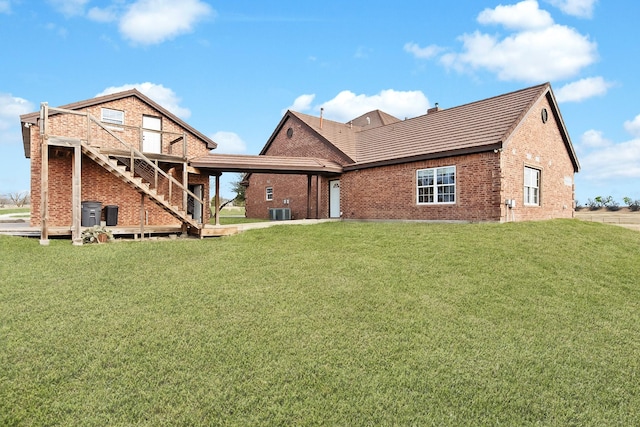 rear view of house featuring a yard and cooling unit