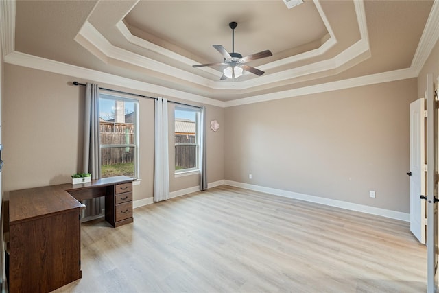 unfurnished office with ornamental molding, light hardwood / wood-style floors, a raised ceiling, and ceiling fan