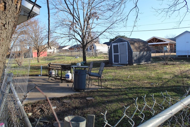 view of yard featuring fence, an outdoor structure, and a shed