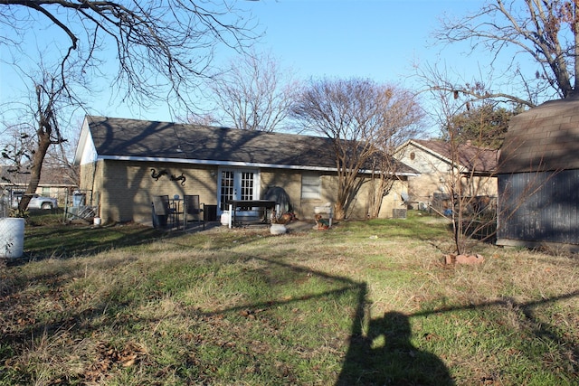 rear view of house with a lawn and french doors