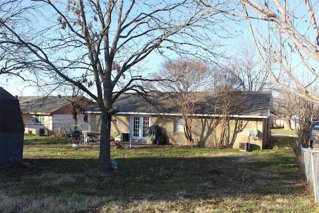 rear view of house featuring a lawn and french doors