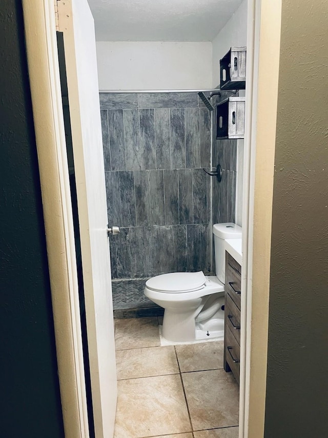 bathroom with vanity, a shower stall, toilet, and tile patterned floors