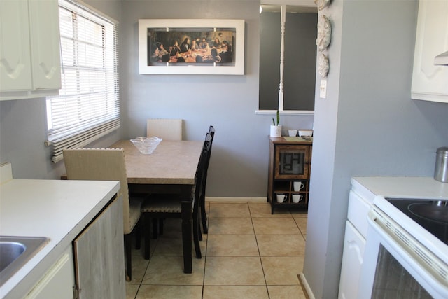 dining space featuring light tile patterned floors and baseboards