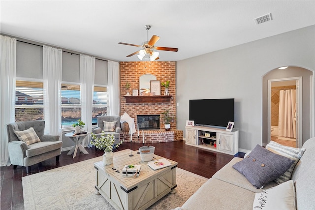 living room featuring ceiling fan, hardwood / wood-style floors, and a fireplace