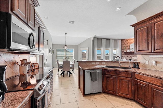 kitchen featuring lofted ceiling, appliances with stainless steel finishes, sink, and light tile patterned floors