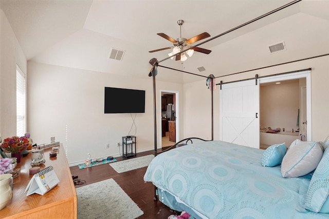 bedroom featuring dark hardwood / wood-style floors, ceiling fan, a barn door, and vaulted ceiling