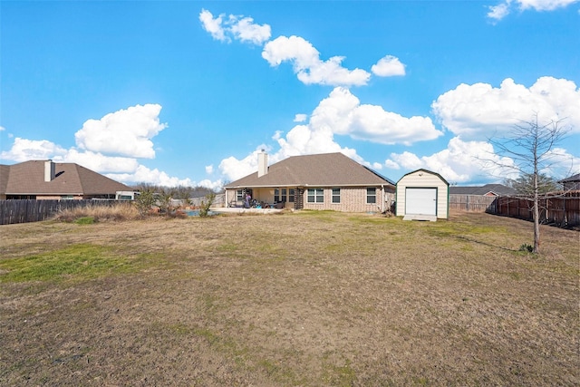 back of property with a shed and a yard