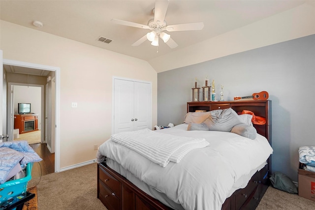 carpeted bedroom with ceiling fan, vaulted ceiling, and a closet