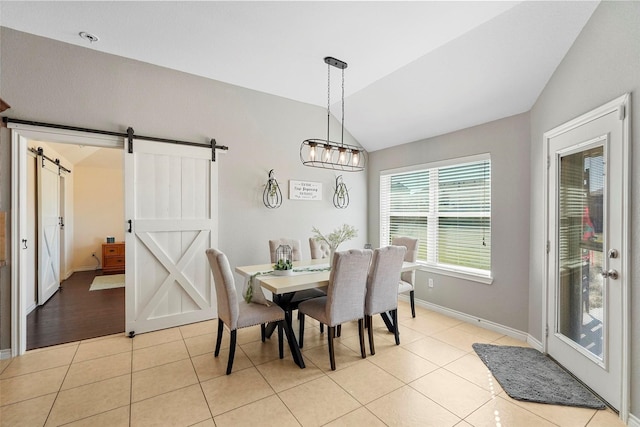 tiled dining space with lofted ceiling, a notable chandelier, and a barn door