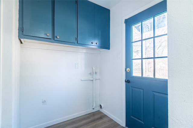 laundry area with dark wood-type flooring, cabinets, and electric dryer hookup